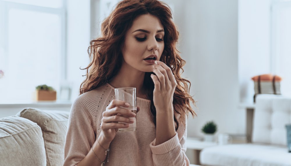 Kobieta zażywa witaminę C na przeziębienie 